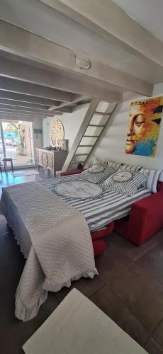 a bedroom with a large bed with a painting on the wall at Duplex piscine calme in Vendémian