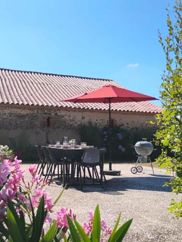 - une table et des chaises avec un parasol dans la cour dans l'établissement country house Land and sea, à Saint-Hilaire-de-Talmont
