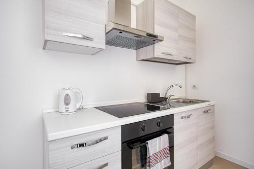 a kitchen with wooden cabinets and a sink at New and bright flat close to Navigli area - Cermenate B4 in Milan