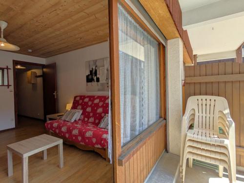 - un salon avec un canapé rouge et une fenêtre dans l'établissement Studio au Centre de La Clusaz - Balcon, Garage, Proche Pistes et Commerces - FR-1-459-67, à La Clusaz