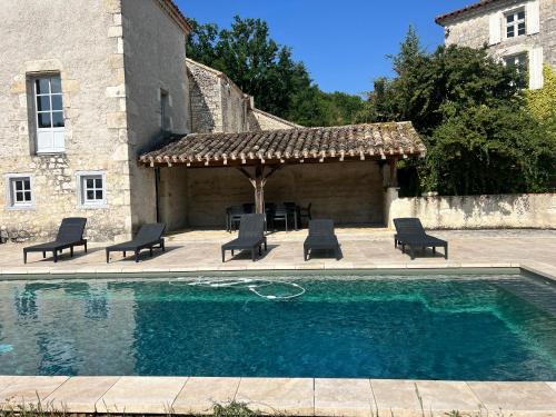 une piscine avec des chaises et un gazebo dans l'établissement Maison 8 couchages piscine privée, à Roquecor