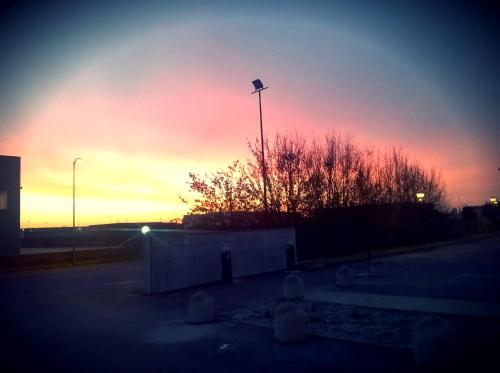 a sunset in a parking lot with a street light at Hotel Motel Giglio in Viadana