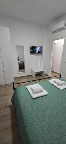 a bedroom with two beds with green sheets and a mirror at DOMUS AISA appartamenti Formia centro in Formia
