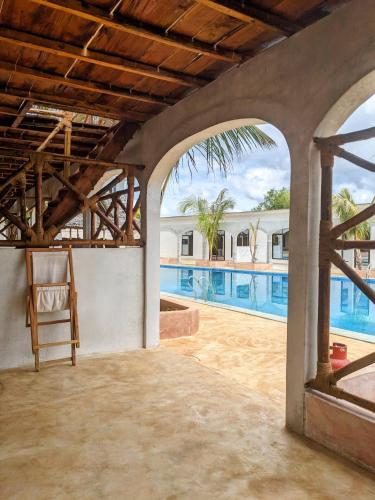 an outdoor patio with a view of a swimming pool at Alcyone Residence - Ocean View Villa in Muyuni