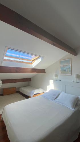 une chambre avec un grand lit blanc et une fenêtre dans l'établissement T4 Beau Duplex Port de plaisance de Capbreton 800m de la plage, à Capbreton