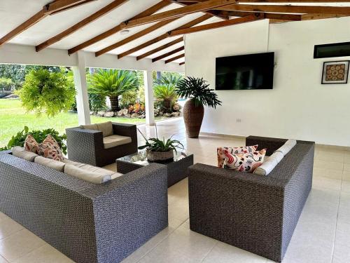 a living room with two couches and a television at Espectacular finca cerca a Buga in Guacarí