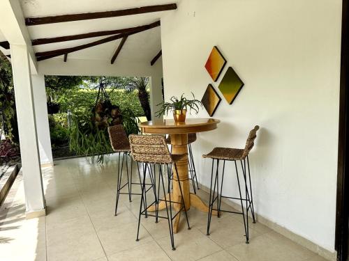 a table and chairs in a room with a patio at Espectacular finca cerca a Buga in Guacarí