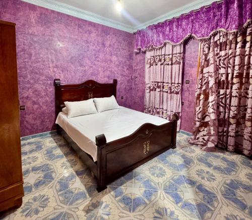 a bedroom with a bed in a purple room at Chalet, para disfrutar de un amanecer, paz y tranquilidad en familia 