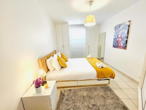 ein Schlafzimmer mit einem Bett mit einer gelben Decke in der Unterkunft City Escape - Cozy 1BR Flat with terrace&parking in Luxemburg (Stadt)