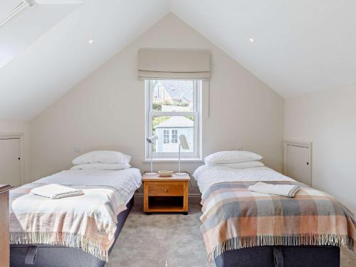 two beds in a white room with a window at 4 Bed in Fowey 82152 in Fowey