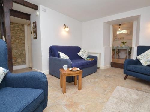 a living room with two blue chairs and a table at 1 Bed in Uploders DC085 in Loders