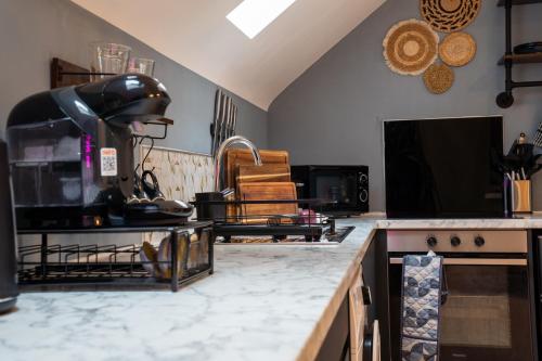 a kitchen with a counter with a stove top oven at Upbeat Jungle Loft Apartment in Derby