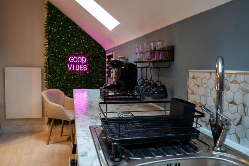 a kitchen with a counter with a sink and a sign that says good vibes at Upbeat Jungle Loft Apartment in Derby