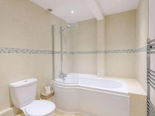 a bathroom with a tub and a toilet and a bath tub at 2 Bed in Langton Matravers DC068 in Langton Matravers
