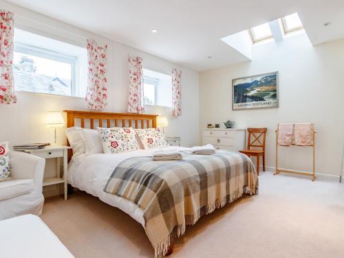 a bedroom with a bed and a chair and windows at 1 Bed in Blacklunans CA361 in Cray