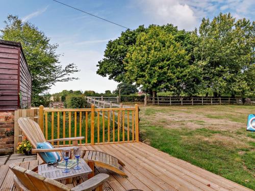 a wooden deck with two chairs and a table at 2 Bed in Hailsham 89416 in Hailsham