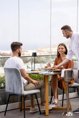 a group of people sitting around a table at Aressana Spa Hotel & Suites - Small Luxury Hotels of the World in Fira