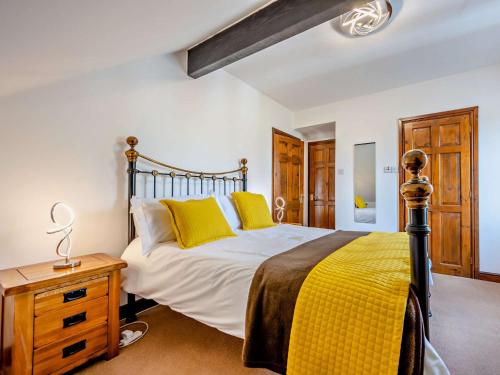 a bedroom with a large bed with yellow pillows at 4 Bed in Troutbeck nr Ullswater SZ256 in Troutbeck