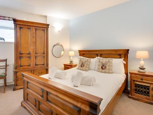 a bedroom with a large wooden bed with white pillows at 2 Bed in Fort Augustus 80700 in Fort Augustus