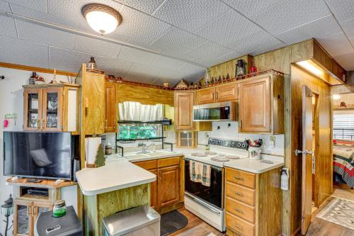 a kitchen with wooden cabinets and a stove top oven at Hike, Swim, Ski and More Pet-Friendly Newland Home! in Newland