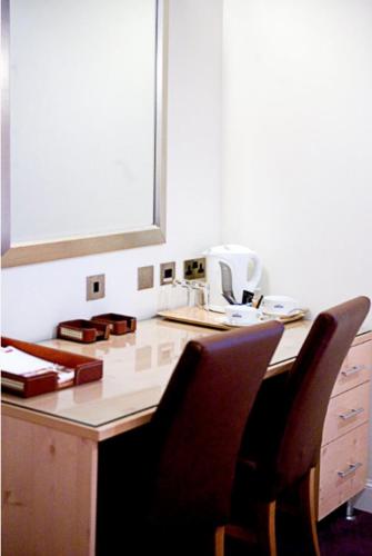 a kitchen with a counter with two chairs at a table at Artto Hotel in Glasgow
