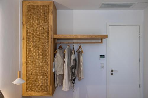 a wooden cabinet with hangers in a room at Bonsai Luxury Villas Naxos in Naxos Chora
