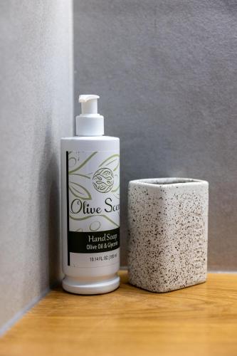 a bottle of divine soap next to a roll of toilet paper at Bonsai Luxury Villas Naxos in Naxos Chora