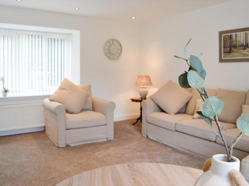a living room with two couches and a table at Kirroughtree Steading 2 - Uk42904 in Newton Stewart