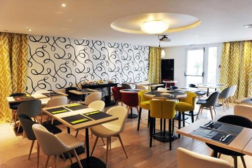 un restaurant avec des tables et des chaises dans une salle dans l'établissement Urban Style Hotel de France, à Vannes