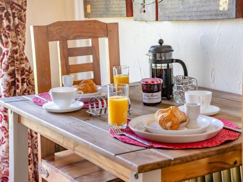 a table with a breakfast of croissants and orange juice at 1 bed property in Gower 77981 in Penclawdd