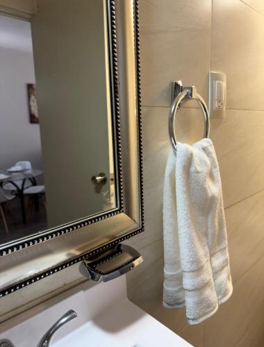 una toalla blanca colgada frente a un espejo en Bellísimo departamento, lo vas a disfrutar!, en Monterrey