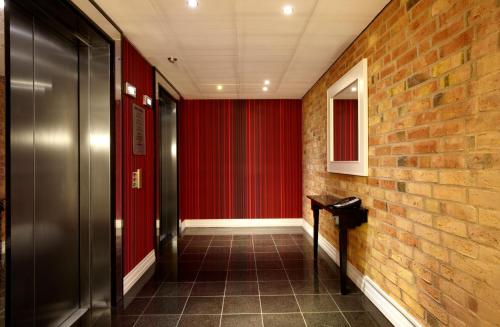 a hallway with red walls and a brick wall at Elite Hotel Esplanade in Malmö