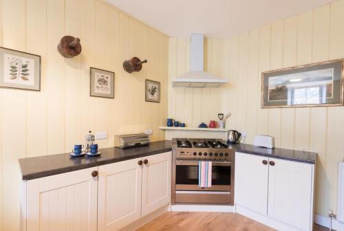 a kitchen with white cabinets and a stove top oven at 2 Bed in Boltongate SZ396 in Mealsgate