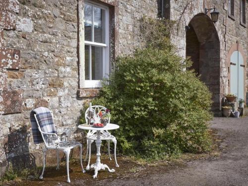 a table and two chairs in front of a building at 2 Bed in Boltongate SZ396 in Mealsgate