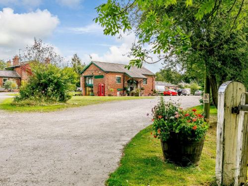 a driveway in front of a house with a gate and flowers at 1 bed in Masham 85511 in Masham