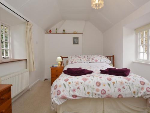 a bedroom with a bed and a dresser and windows at 1 Bed in Burton Bradstock DC178 in Burton Bradstock