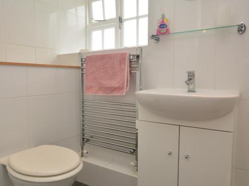 a white bathroom with a toilet and a sink at 1 Bed in Burton Bradstock DC178 in Burton Bradstock