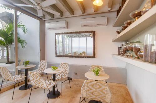 a room with tables and chairs and a mirror at Sol de Alba Hotel Boutique in Cartagena de Indias