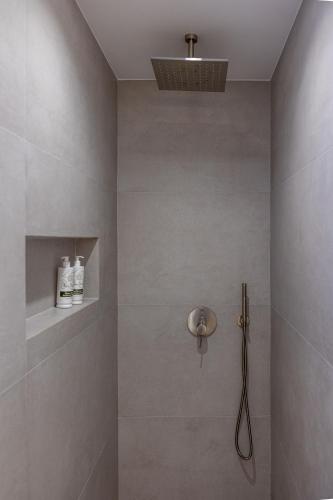 a bathroom with a shower with a shower head at Bonsai Luxury Villas Naxos in Naxos Chora