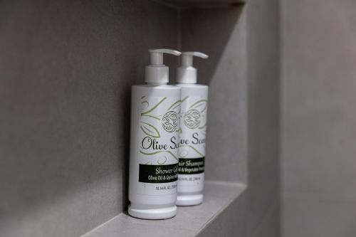 two bottles of glue suds sitting on a shelf at Bonsai Luxury Villas Naxos in Naxos Chora
