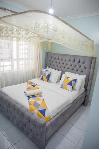 a bedroom with a large bed with a canopy at SpringStone executive apartment A15 in Ongata Rongai 