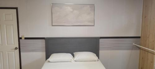 a bedroom with a bed with two pillows on it at WhiteCourt in Abbotsford