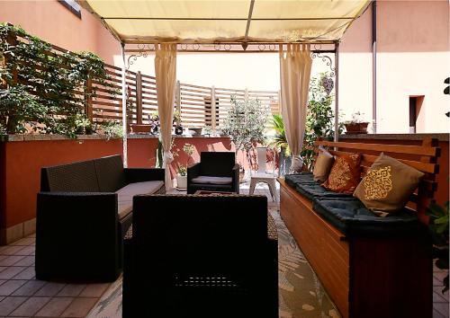 a porch with a couch and chairs on a patio at Appartamento Il Crocevia in Piacenza