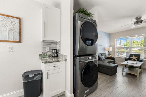 a kitchen with a living room with a large refrigerator at Sun and Sea By Beachside Management in Siesta Key