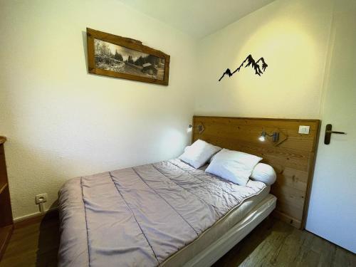 une chambre avec un lit avec un tableau sur le mur dans l'établissement Appartement confort 6 pers, belle vue montagne, ski-in ski-out aux Menuires - FR-1-452-96, aux Menuires