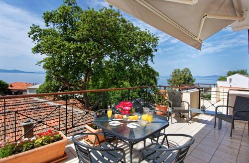 a patio with a table and chairs on a balcony at Katia Hotel in Afissos