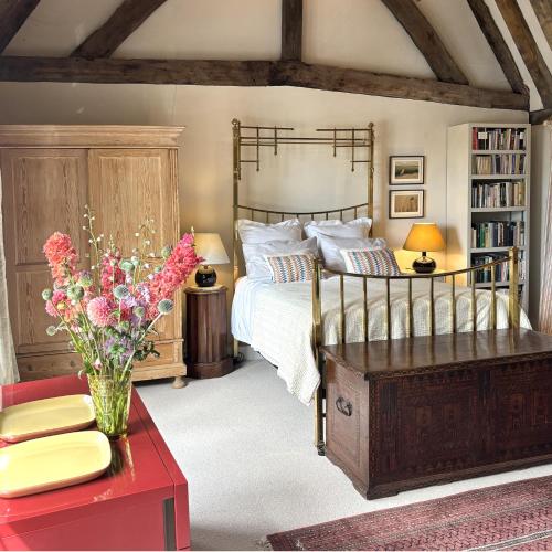 a bedroom with a bed and a vase of flowers at Woolmarket House in King's Lynn
