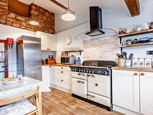 a kitchen with white cabinets and a stove at 1 Bed in Washford 81240 in Washford