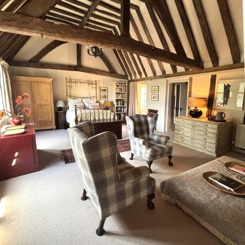 a living room with two chairs and a bed at Woolmarket House in King's Lynn