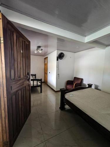 a room with a bed and a chair and a door at Liahs tortuguero in Tortuguero